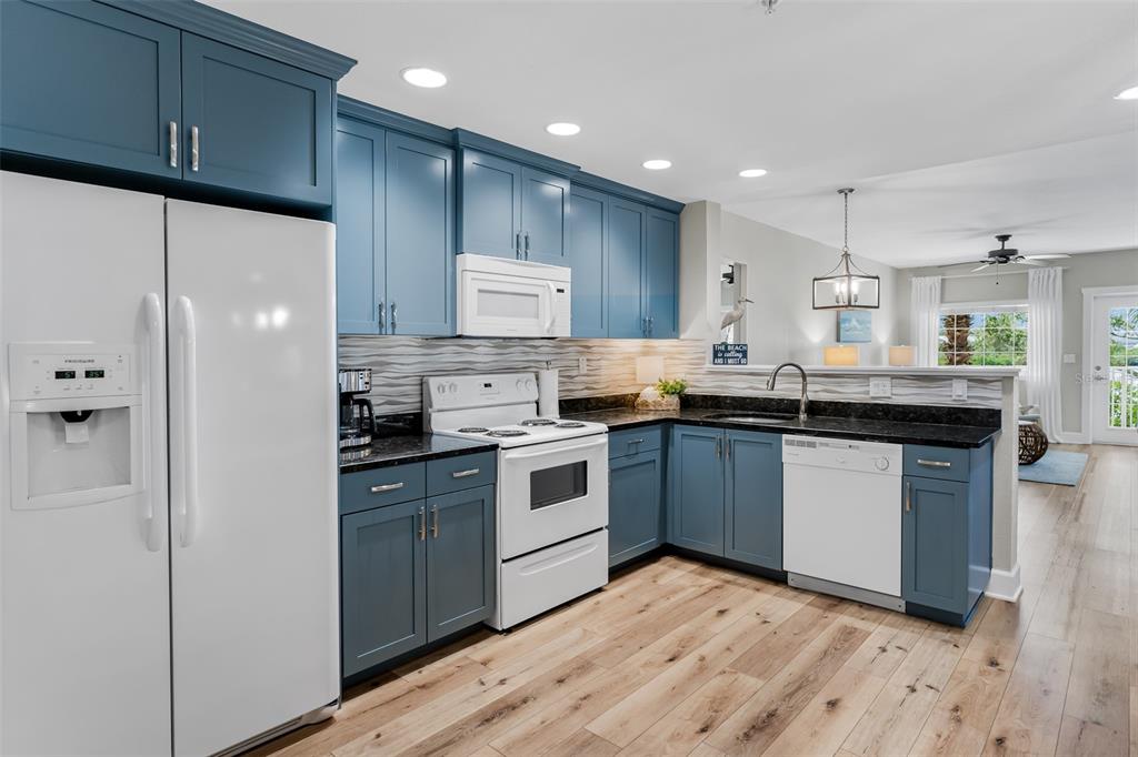 399 2nd Street, Unit 215 Indian Rocks Beach, FL 33785 - Photo 11 of 51 a kitchen with stainless steel appliances granite countertop a stove a sink dishwasher and a refrigerator