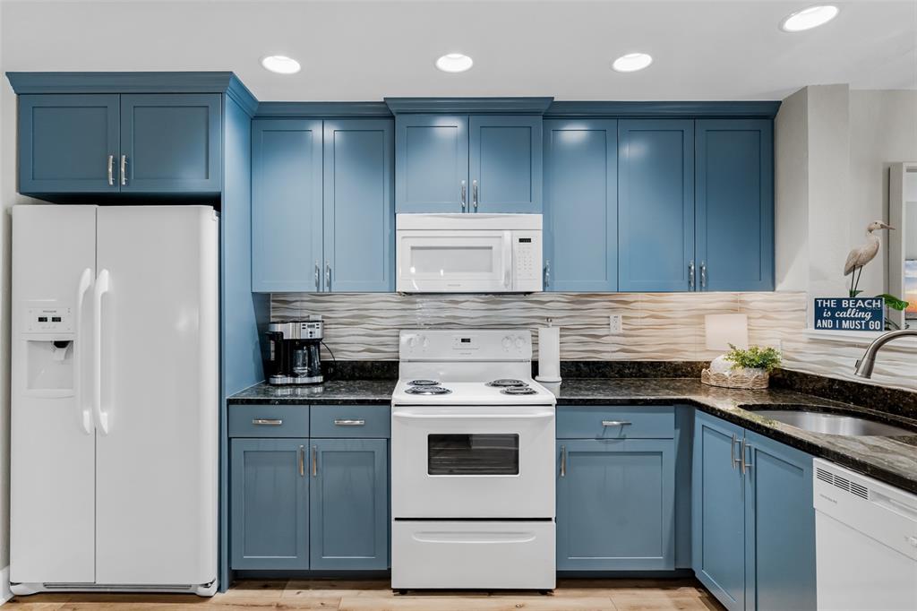 399 2nd Street, Unit 215 Indian Rocks Beach, FL 33785 - Photo 12 of 51 a kitchen with cabinets appliances and a counter space