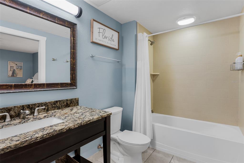 399 2nd Street, Unit 215 Indian Rocks Beach, FL 33785 - Photo 27 of 51 a bathroom with a granite countertop sink toilet and shower