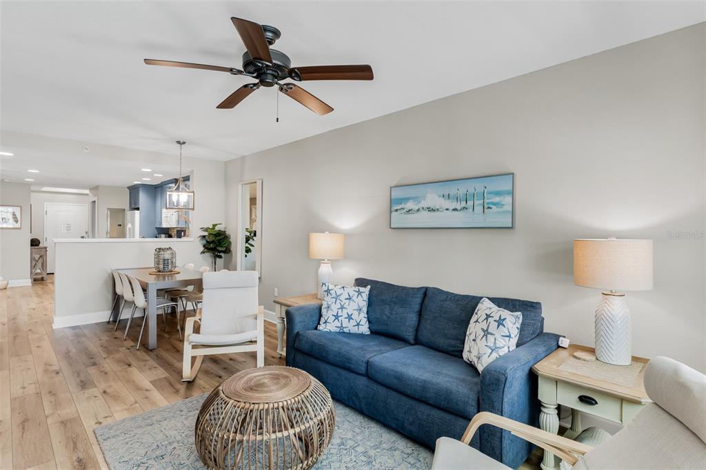 399 2nd Street, Unit 215 Indian Rocks Beach, FL 33785 - Photo 6 of 51 a living room with furniture a rug and a chandelier
