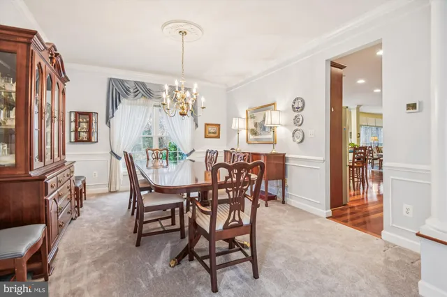 a dining room with furniture a chandelier and wooden floor