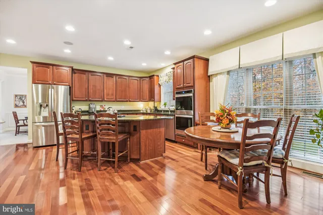 a room with stainless steel appliances kitchen island granite countertop furniture and a wooden floors