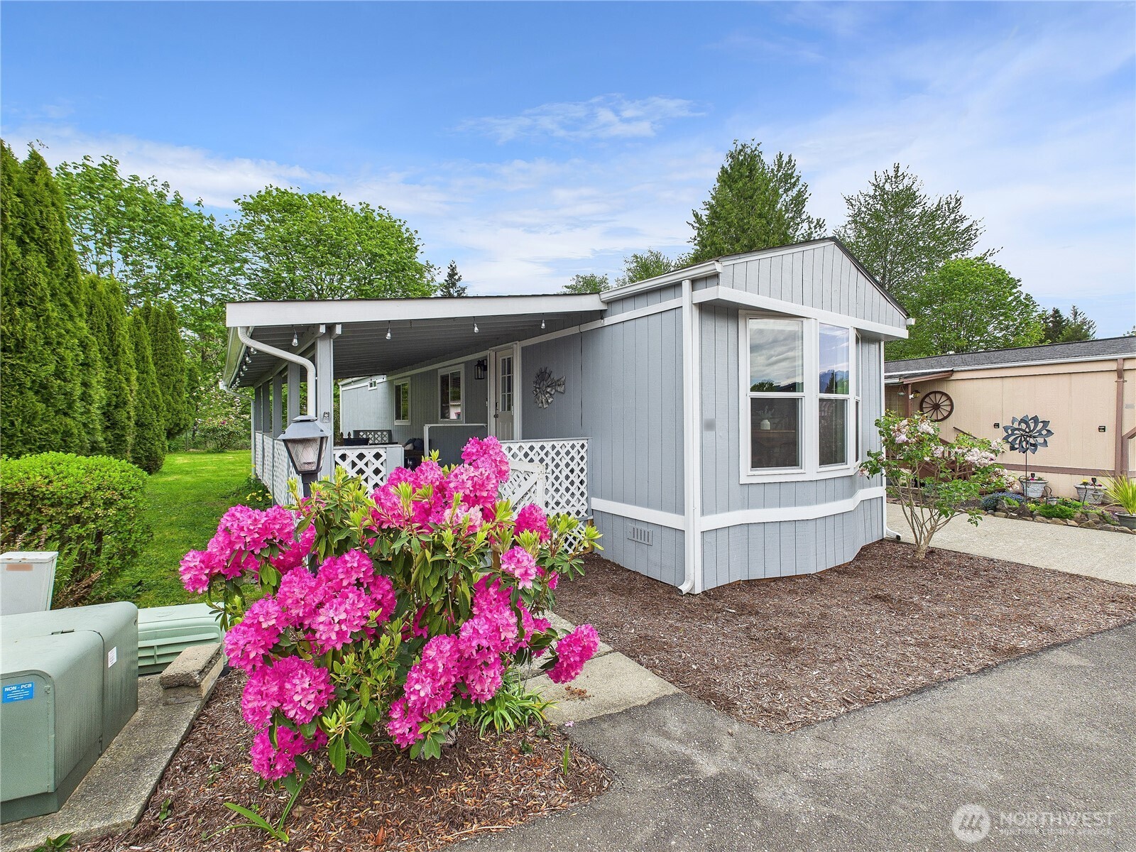 a view of a white house with a flower garden and chair