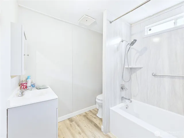 a white bath tub sitting next to a white sink and vanity