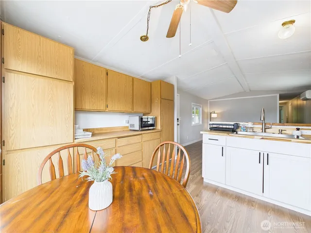 a kitchen with stainless steel appliances granite countertop a sink a stove a refrigerator with a dining table and chairs