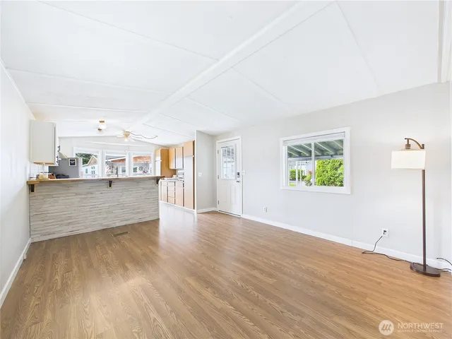 a view of a kitchen with wooden floor and windows