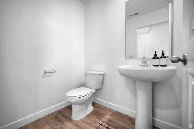 2123 Wolverine Way, Unit 2437 Washington, UT 84780 - Photo 25 of 40 Pedestal sink with chrome faucet, wall-mounted mirror, and wood-finish flooring