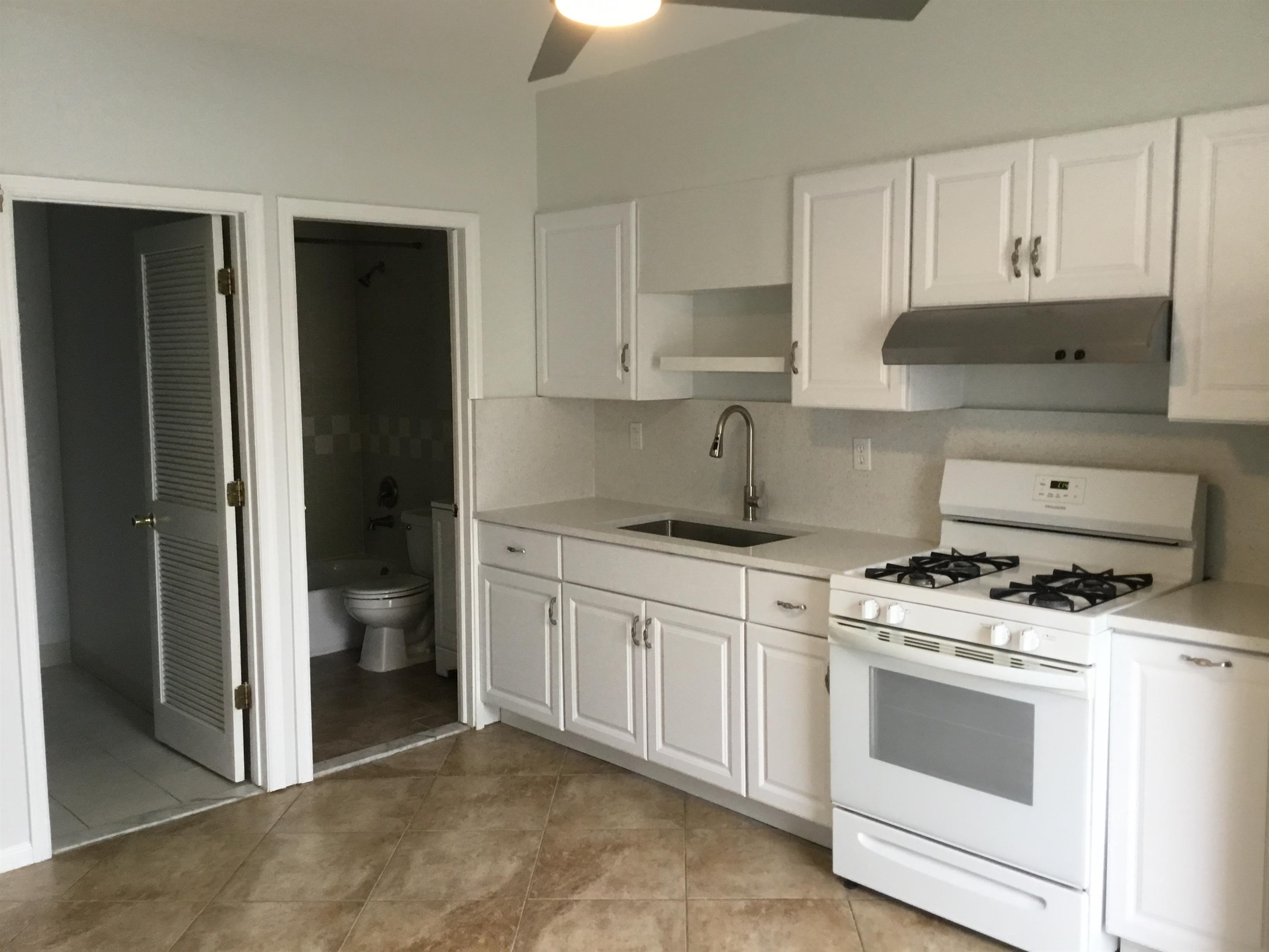 90 Union Avenue, Unit 2 Little Ferry, NJ 07643 - Photo 4 of 25 a kitchen with white cabinets and white appliances
