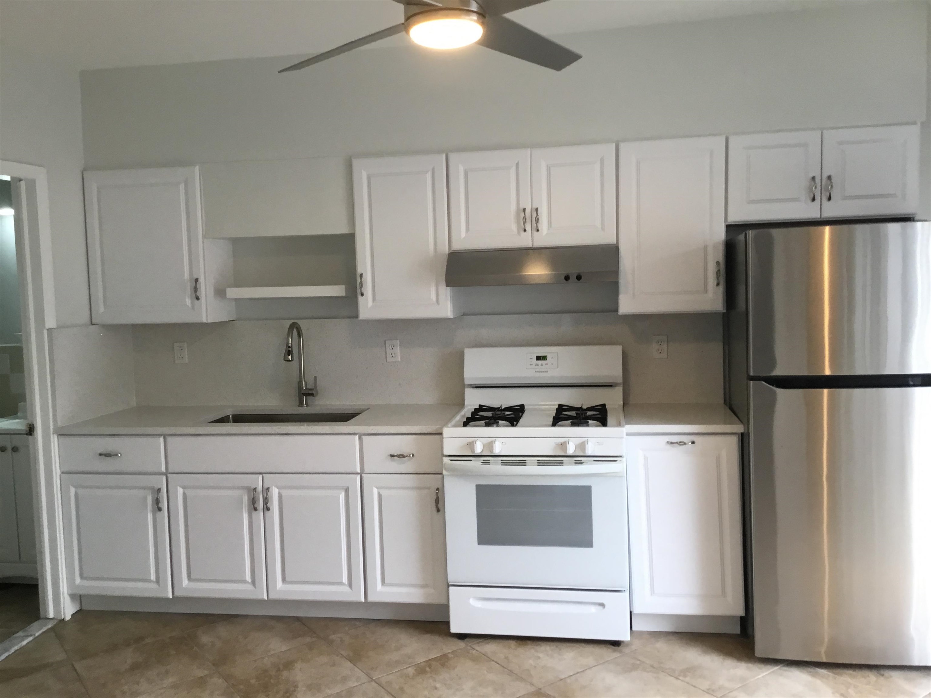 90 Union Avenue, Unit 2 Little Ferry, NJ 07643 - Photo 5 of 25 a kitchen with white cabinets and white appliances