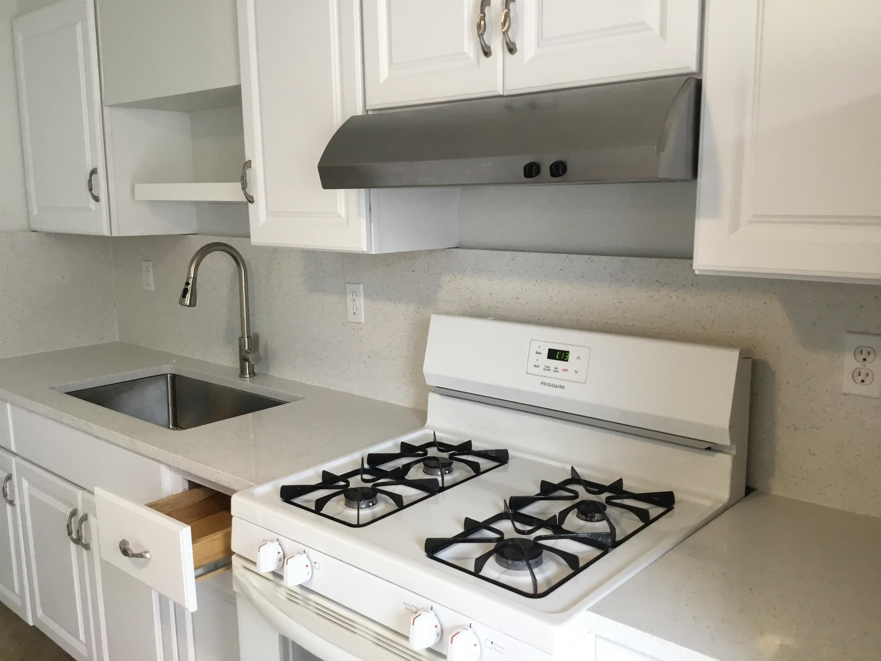 90 Union Avenue, Unit 2 Little Ferry, NJ 07643 - Photo 7 of 25 a kitchen with a stove and a white cabinets