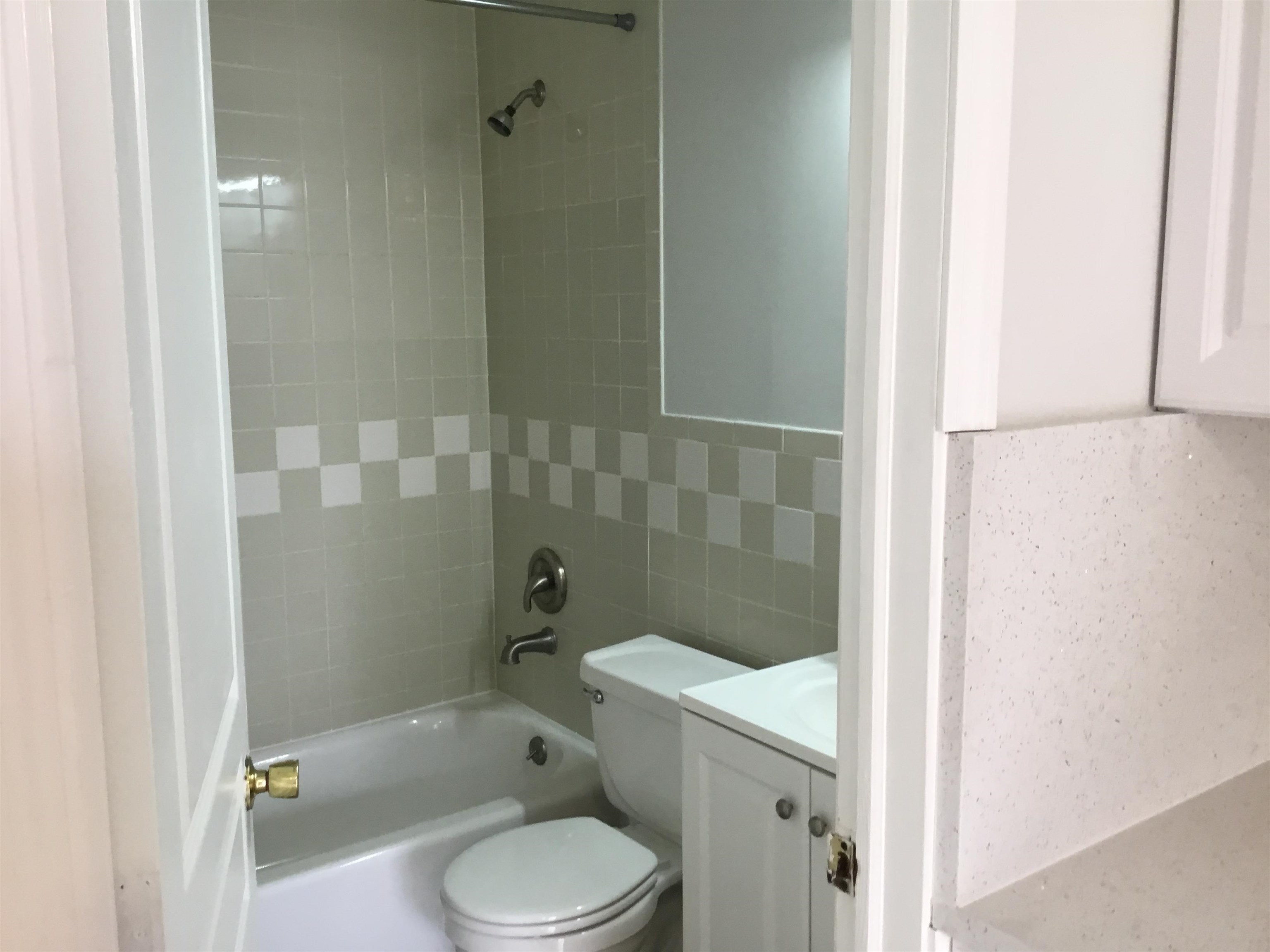 90 Union Avenue, Unit 2 Little Ferry, NJ 07643 - Photo 10 of 25 a white toilet sitting next to a bathroom sink