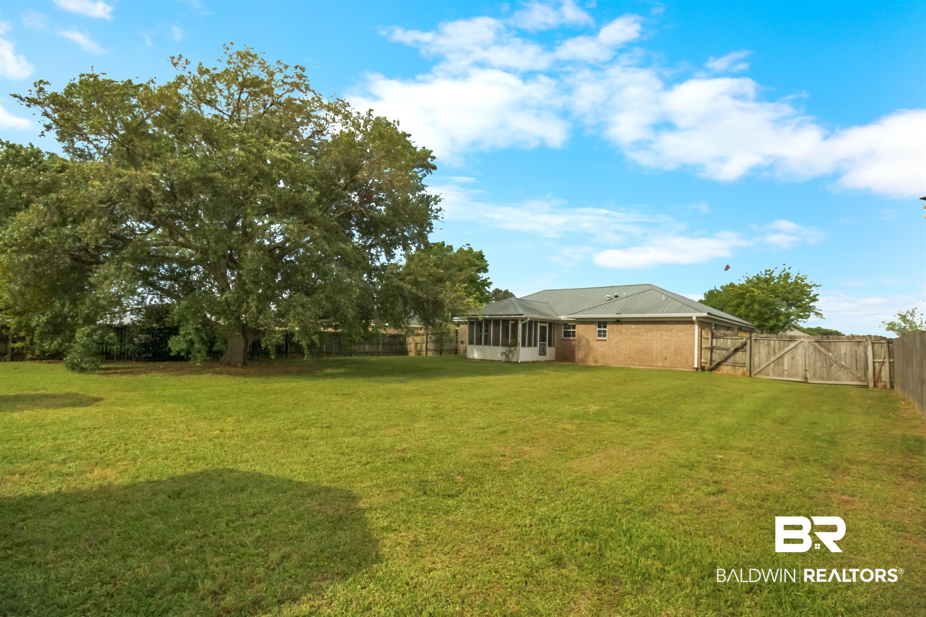 8940 Caitlin Street Foley, AL 36535 - Photo 25 of 27 Fenced backyard featuring a gate and a sunroom