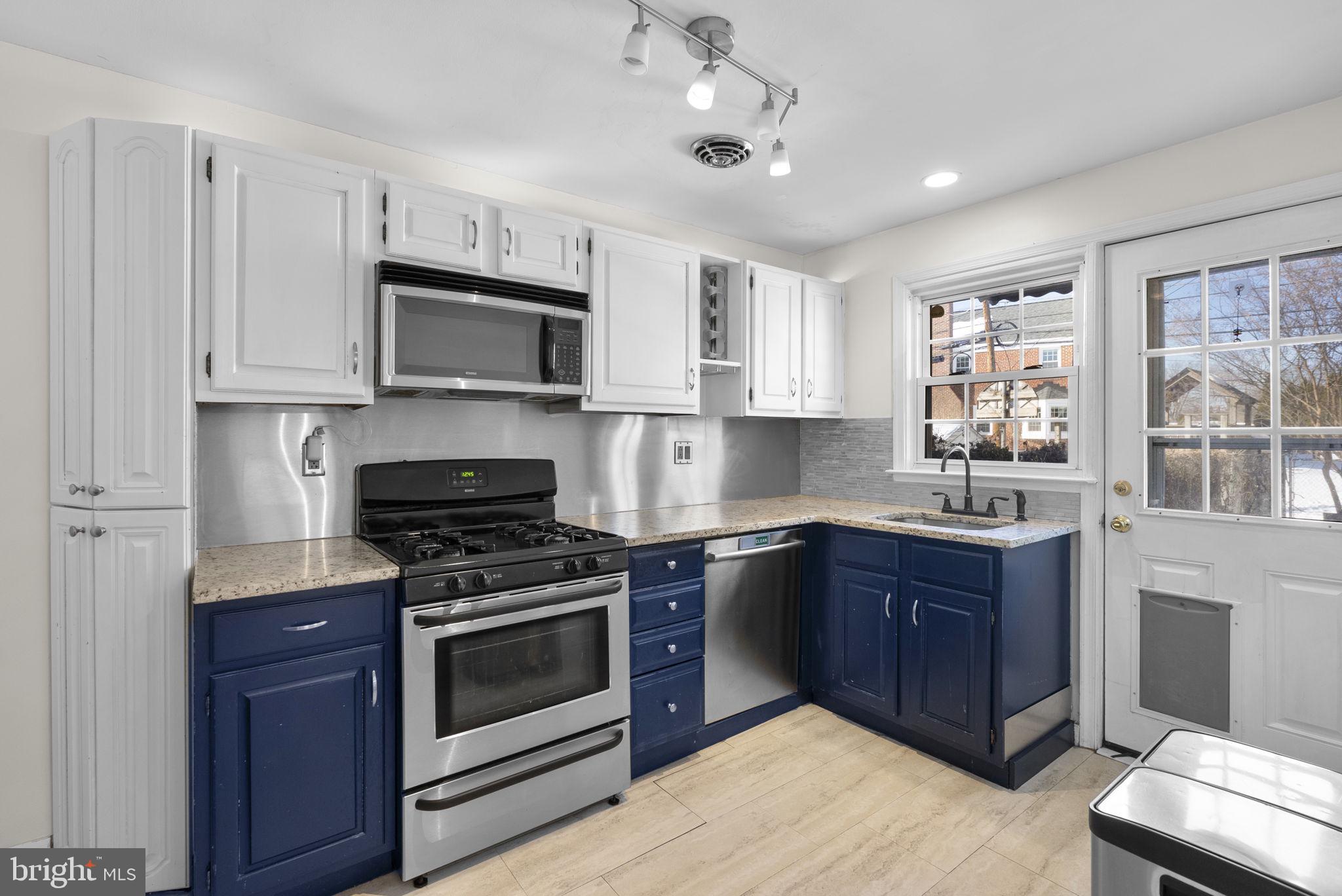 8204 Pleasant Plains Road Towson, MD 21286 - Photo 12 of 40 a kitchen with stainless steel appliances granite countertop a stove top oven a sink dishwasher and a microwave oven with cabinets