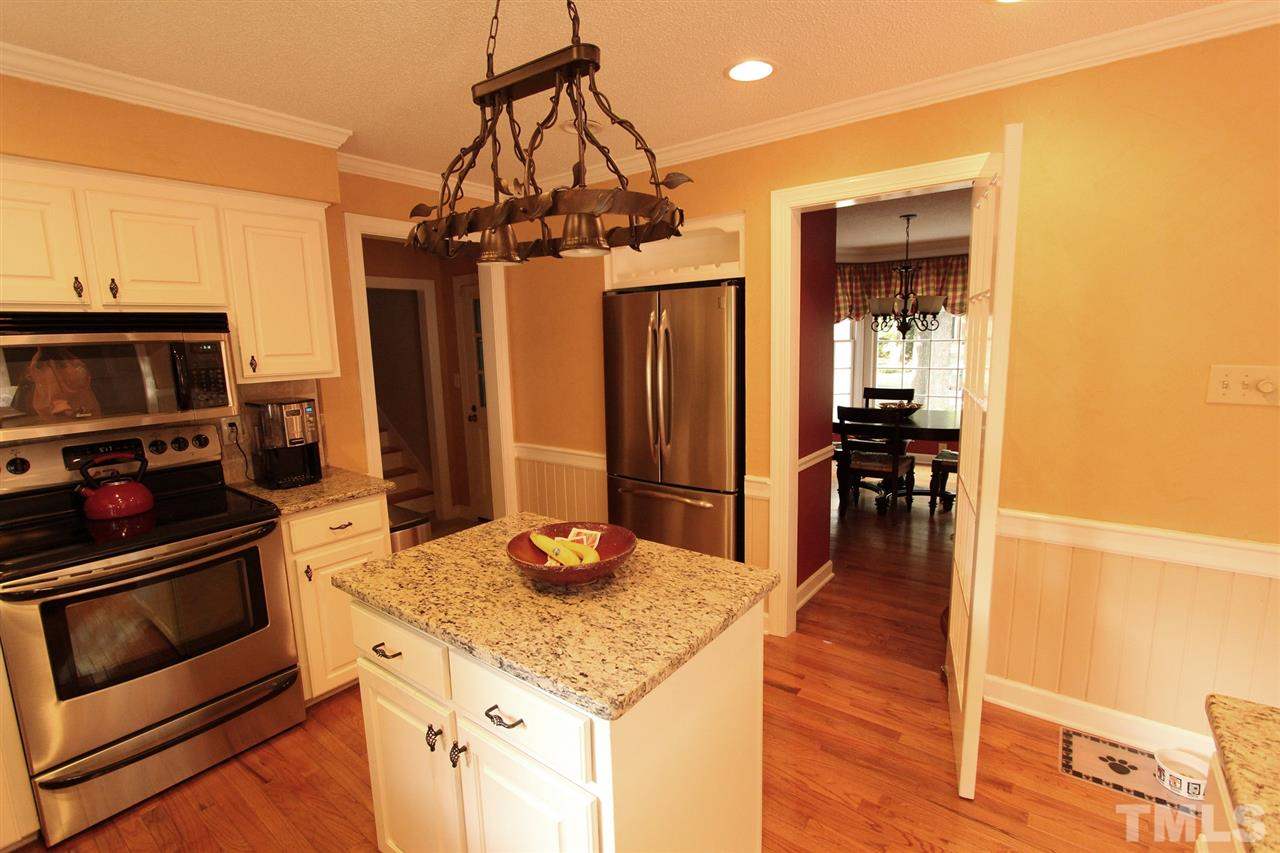 8317 Apple Orchard Way Raleigh, NC 27615 - Photo 3 of 12 a kitchen with stainless steel appliances granite countertop a sink a stove and refrigerator