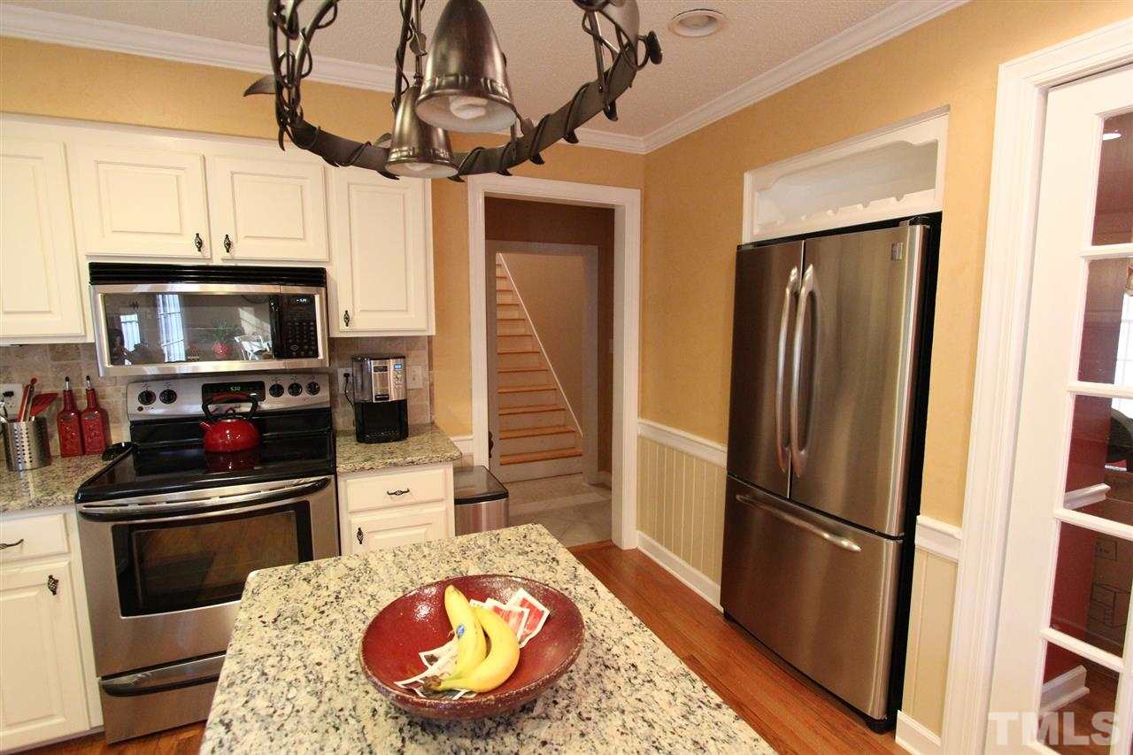 8317 Apple Orchard Way Raleigh, NC 27615 - Photo 4 of 12 a kitchen with a refrigerator and a stove