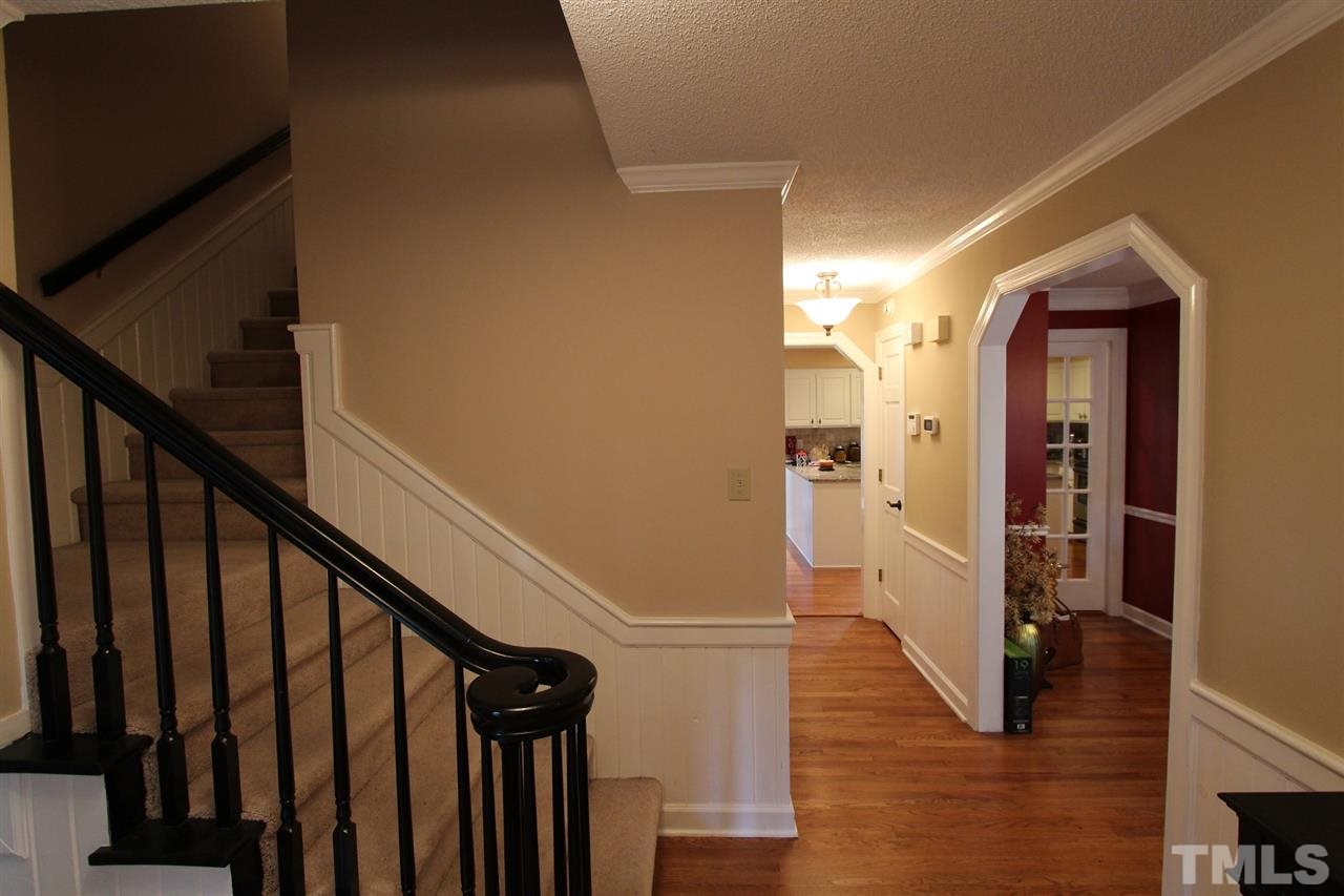 8317 Apple Orchard Way Raleigh, NC 27615 - Photo 6 of 12 a view of a hallway with wooden floor and staircase