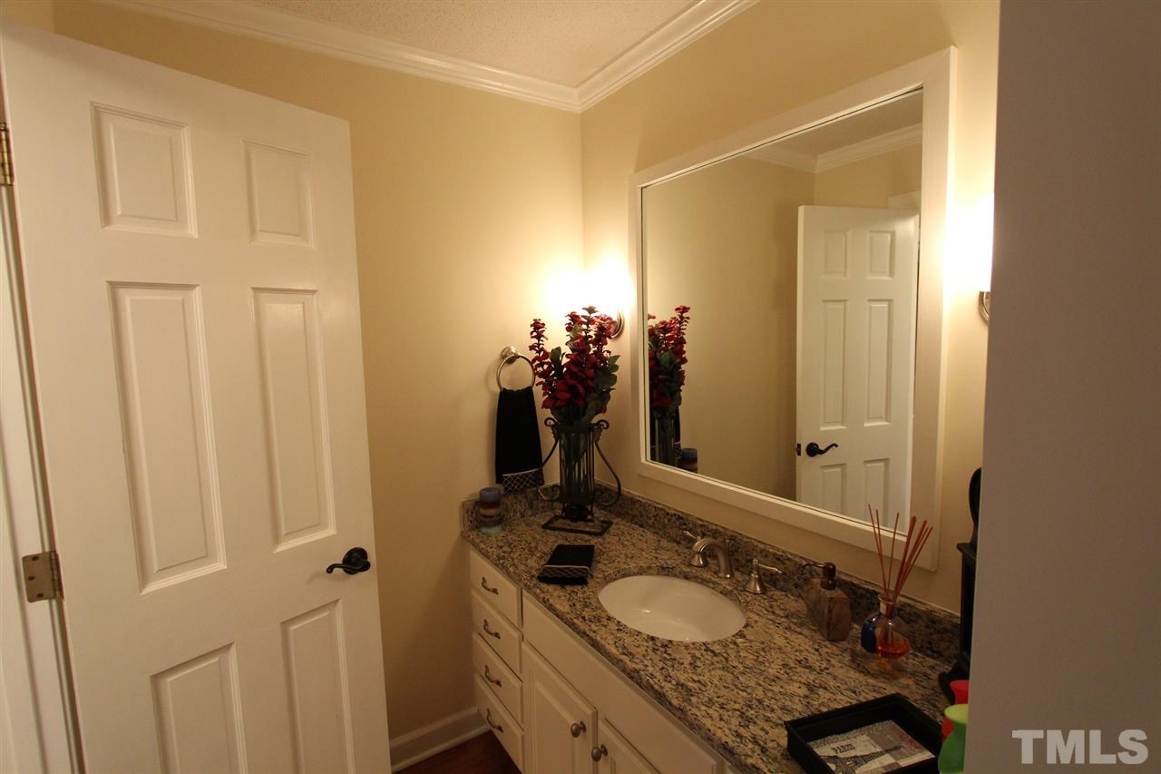 8317 Apple Orchard Way Raleigh, NC 27615 - Photo 7 of 12 a bathroom with a granite countertop sink and a mirror