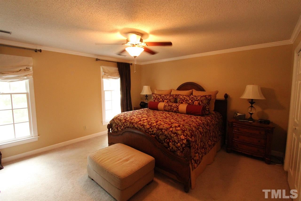 8317 Apple Orchard Way Raleigh, NC 27615 - Photo 8 of 12 a bedroom with a bed and a chandelier