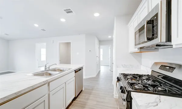 a kitchen with sink stove and cabinets