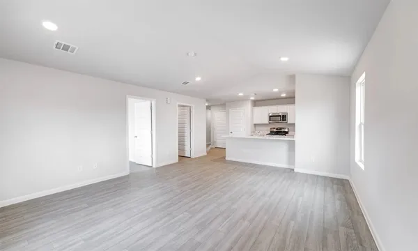 a view of a kitchen with wooden floor and windows