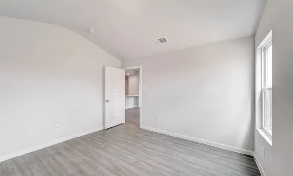 a view of an empty room with wooden floor