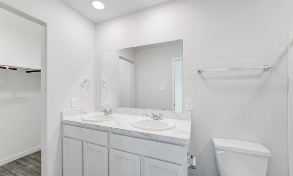 a bathroom with a granite countertop sink a toilet and a mirror