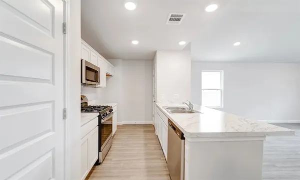 a kitchen with stainless steel appliances granite countertop a sink stove and refrigerator