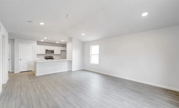 a view of kitchen with kitchen island stainless steel appliances wooden floor and window