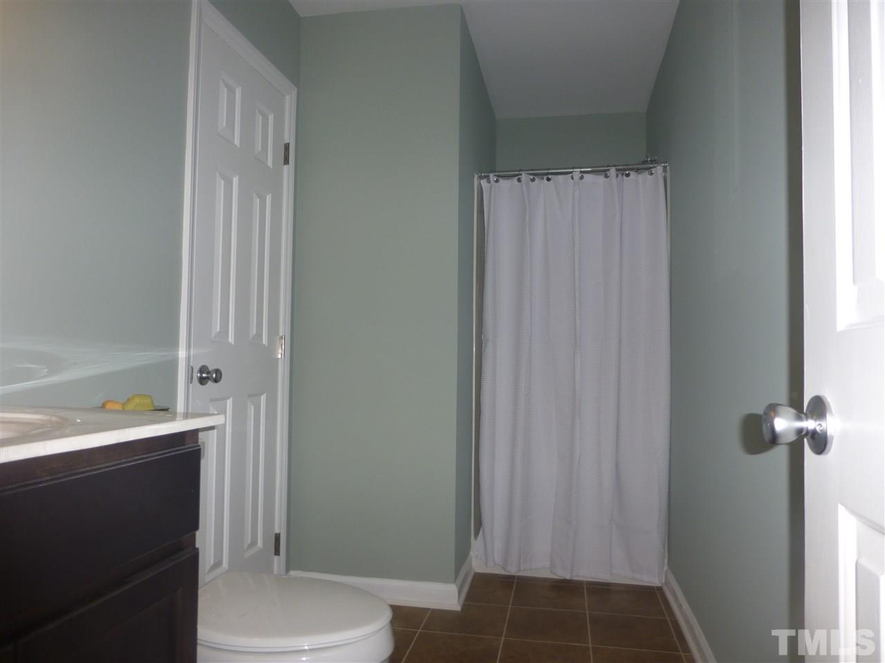 3612 Epperly Court Raleigh, NC 27616 - Photo 21 of 25 a bathroom with a sink a toilet a shower and a window