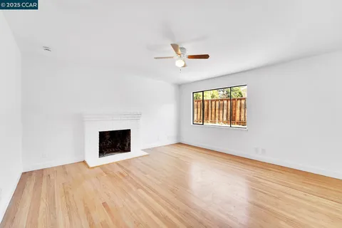 an empty room with windows and fireplace