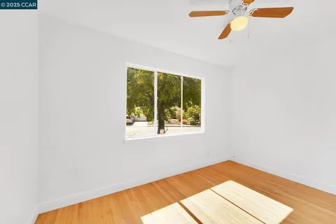 a view of a room with wooden floor and a window