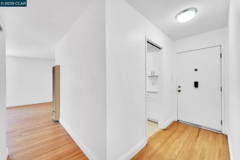 a view of a room with wooden floor and a ceiling fan