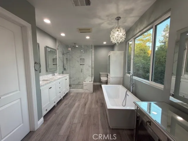 a spacious bathroom with a granite countertop sink a toilet a mirror and a bathtub
