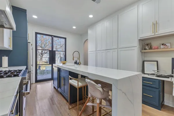 a kitchen with a stove a refrigerator and a stove with wooden floor