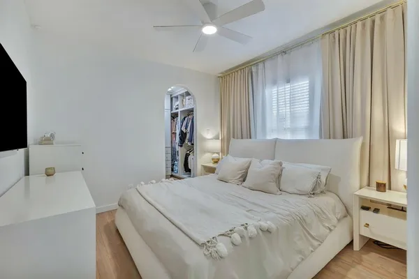 a bedroom with a bed and a flat tv screen on the dresser