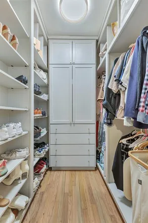 a view of walk in closet with clothes and shoes