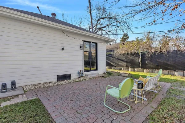 a view of a chair and table in backyard of the house
