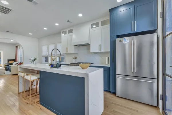 a kitchen with kitchen island a sink stainless steel appliances and cabinets