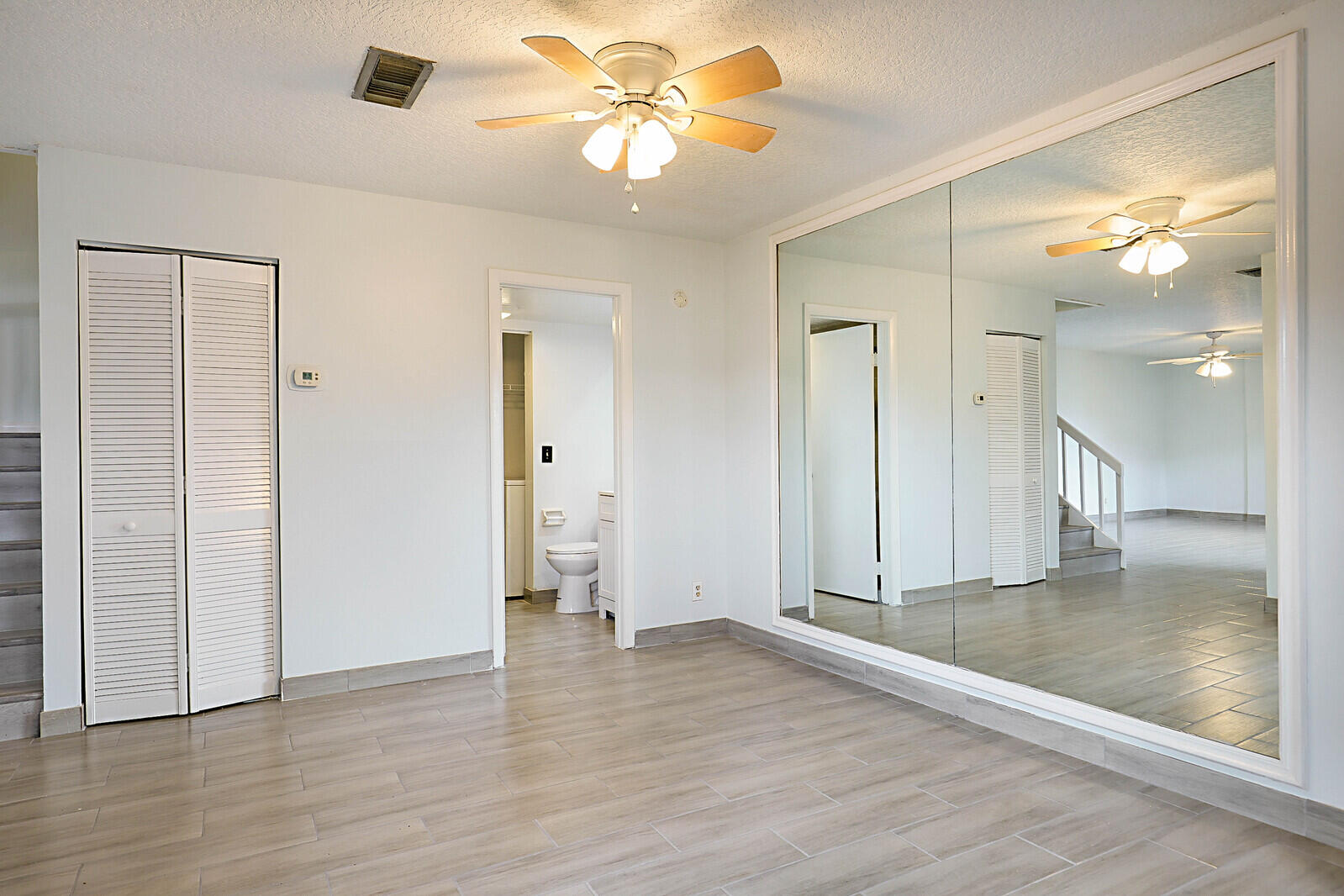 253 Woodland Road Palm Springs, FL 33461 - Photo 14 of 27 a view of a big room with wooden floor and a ceiling fan
