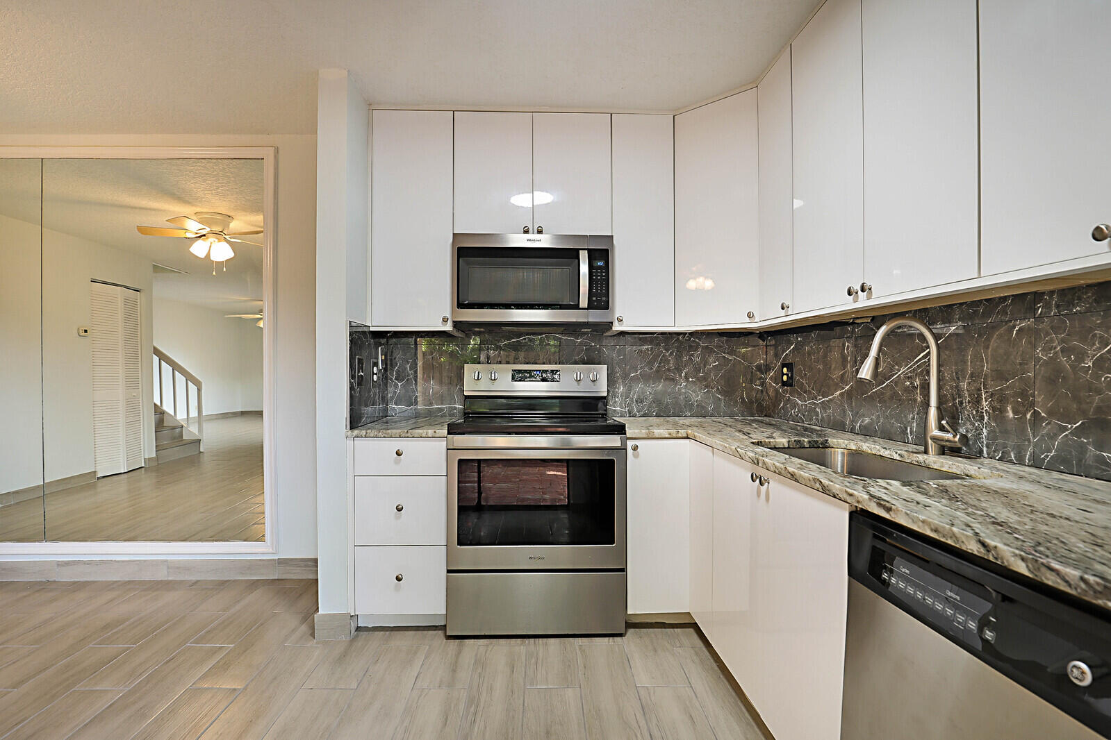 253 Woodland Road Palm Springs, FL 33461 - Photo 3 of 27 a kitchen with a sink and a stove top oven