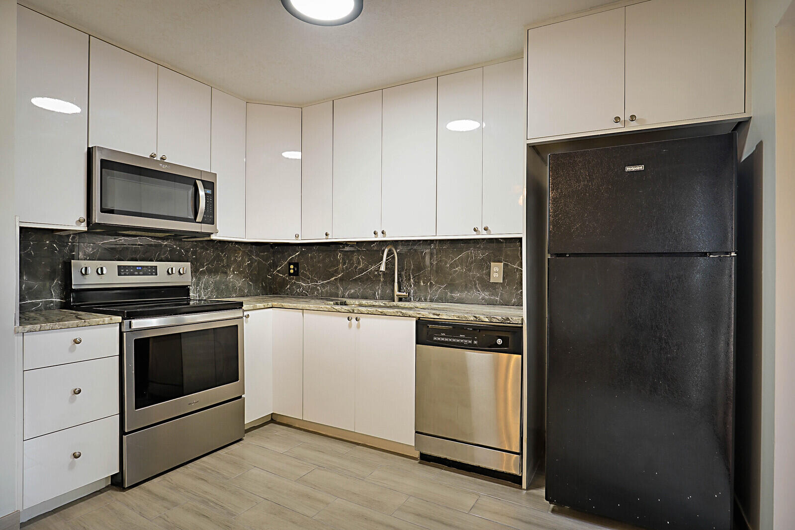 253 Woodland Road Palm Springs, FL 33461 - Photo 4 of 27 a kitchen with a refrigerator stove and microwave