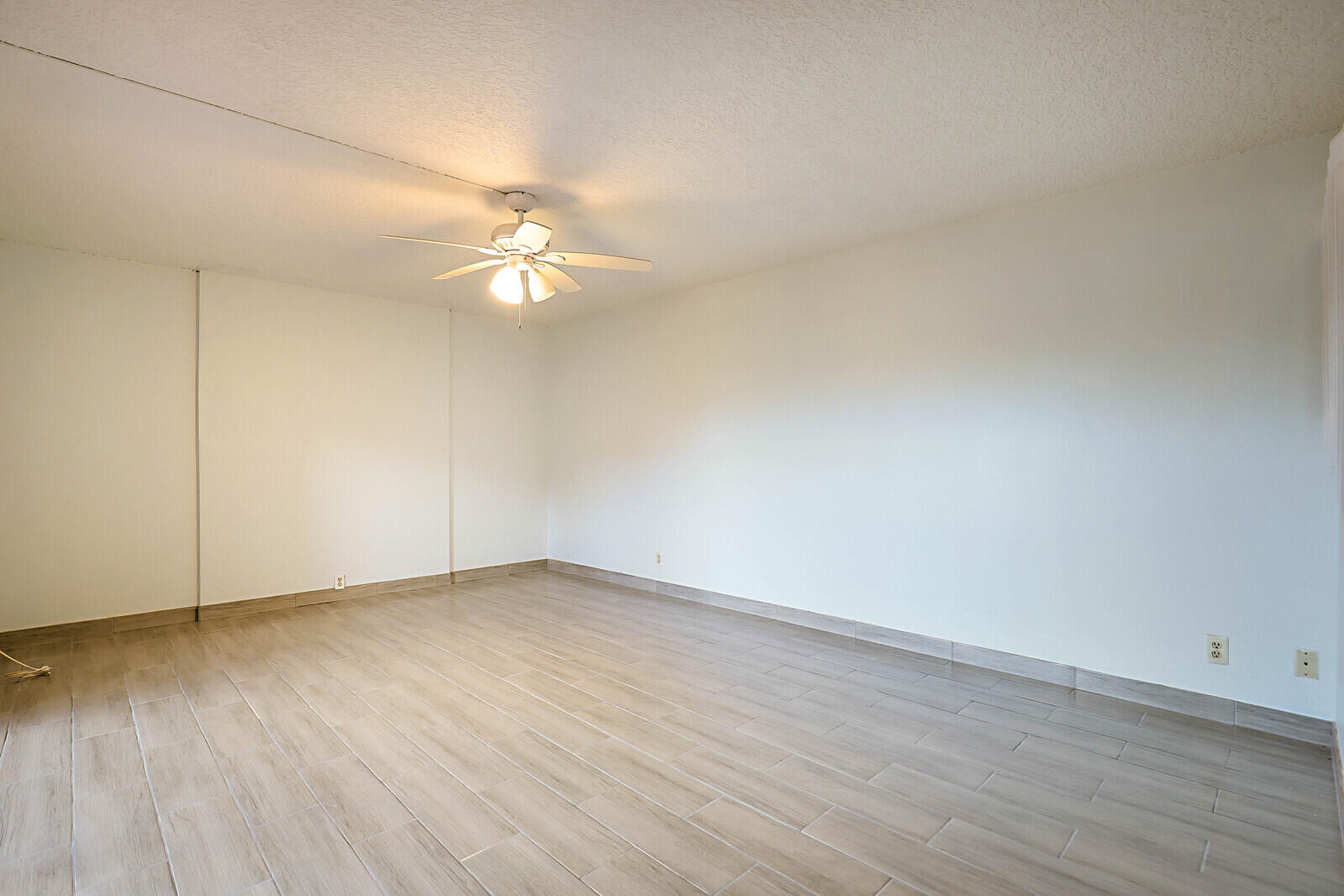 253 Woodland Road Palm Springs, FL 33461 - Photo 9 of 27 a view of an empty room with wooden floor