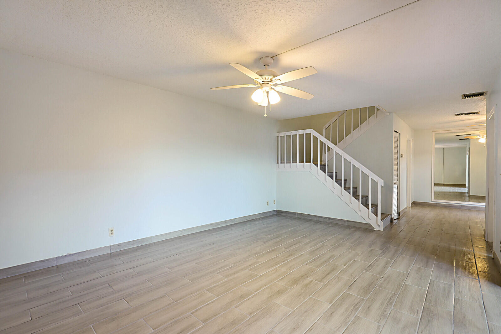 253 Woodland Road Palm Springs, FL 33461 - Photo 10 of 27 an empty room with wooden floor fan and windows
