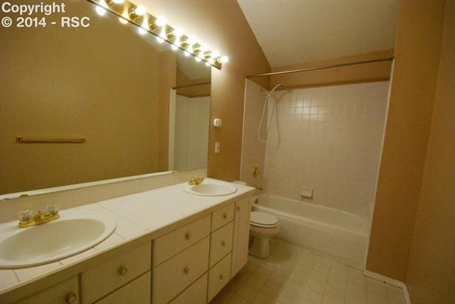 9575 Hardin Road Colorado Springs, CO 80908 - Photo 18 of 24 Down the hall is the secondary bathroom for the 3 upstairs, secondary bedrooms. Notice the double sinks and vaulted ceilings.