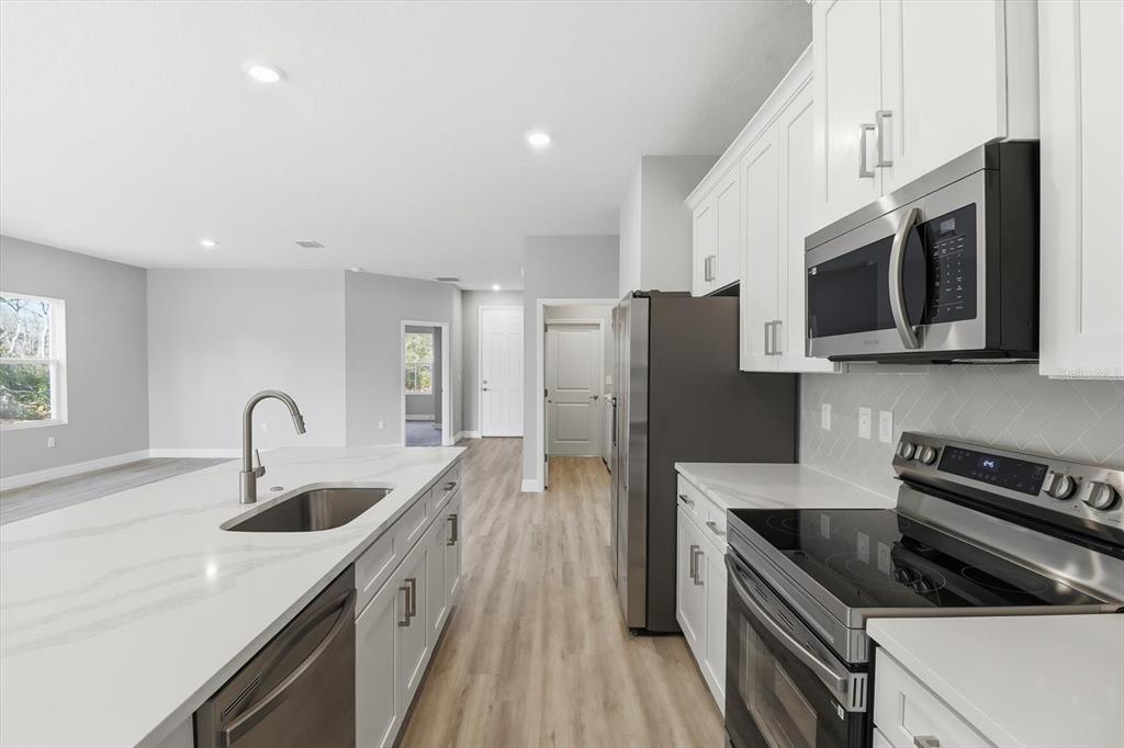 16604 Southwest 21st Circle Ocala, FL 34473 - Photo 12 of 43 a kitchen with stainless steel appliances granite countertop a sink stove and refrigerator
