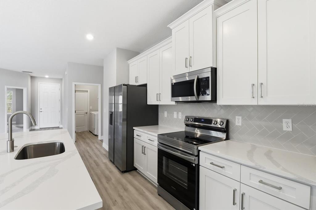 16604 Southwest 21st Circle Ocala, FL 34473 - Photo 13 of 43 a kitchen with a sink a stove and refrigerator