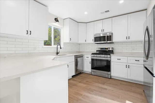 a kitchen with stainless steel appliances a white stove top oven and sink
