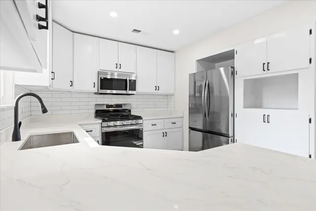 a kitchen with refrigerator a microwave a sink and a stove