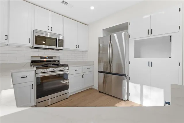 a kitchen with stainless steel appliances a refrigerator stove and microwave