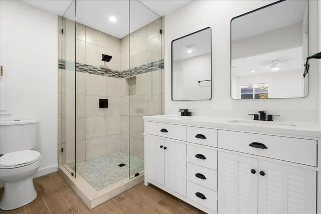 a bathroom with a shower sink mirror and toilet
